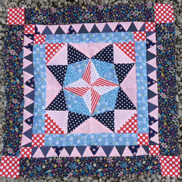 a 4 point star surrouned by an 8 point star and two blue pink borders