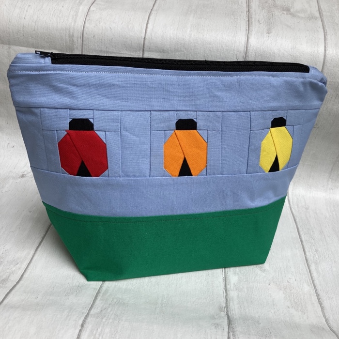 A handmade Bug bag pouch with colourful bags on the side