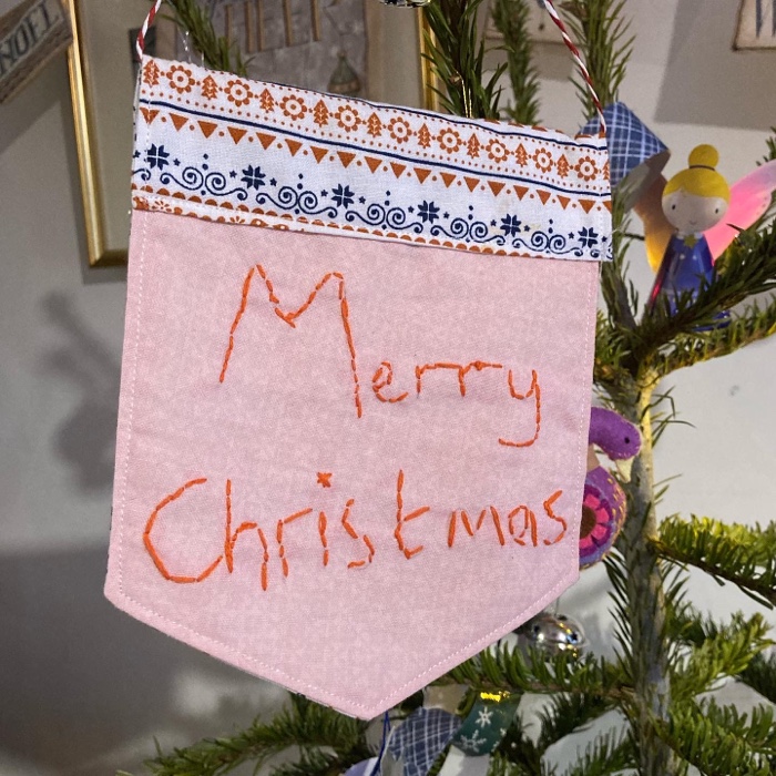 a christmas banner that says Merry Christmas on it in stitches that the 5 year old did