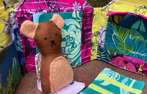 Bitsy Bear is brown and sat in a deck chair