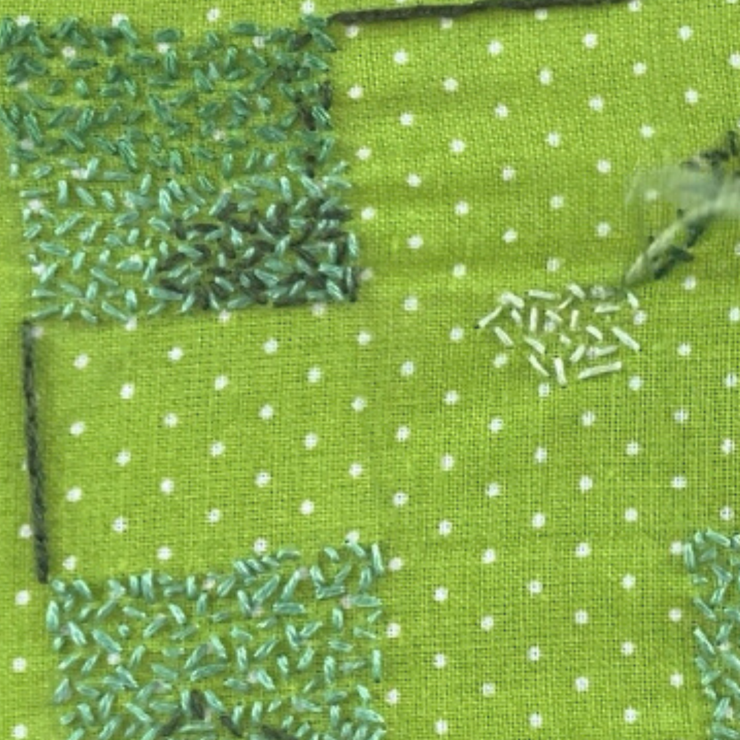 A cluse up of the seed stitch in green thread