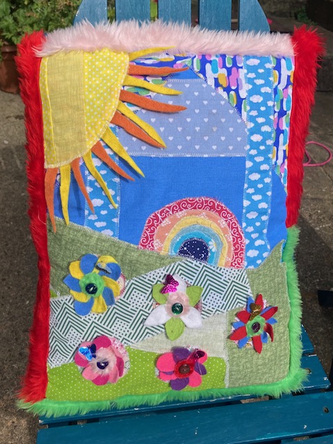 A rainbow colourful button cushion