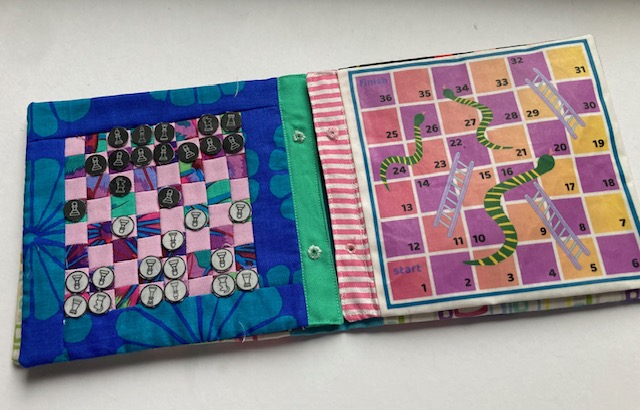 A handmade fabric chess board and snakes and ladders board